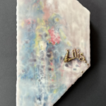 trapezoid shaped substrate tilted up on end like a flag blowing toward the right, the encaustic painting is a smooth surface that has lovely melted speckles and splotches of carnival-like turquoise, dark purple, bright red, yellow and white all diffused by layers of clear semi-transparent encaustic medium that attempted to cover them completely, but failed; the name Lilis is sculpted with wrapped gold wire and attached with golden nails to the right center portion of the piece, the heat of the wire when the wax was burned in a final time created an indentation around the name as though is sunk slightly into a couch cushion