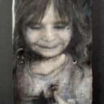 warm and cool black and white close up view of a child with bangs and loose curly hair smiling and looking down at a lightning bug on her finger