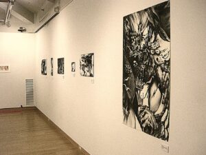 the artist's college artwork hanging in a gallery exhibition